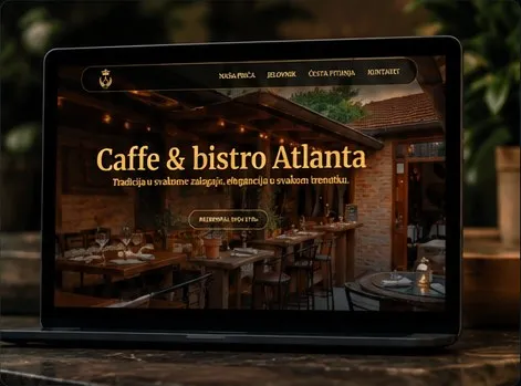 Laptop screen displaying the website homepage of Caffe & Bistro Atlanta with a cozy indoor restaurant dining area and navigation menu in a dark theme.